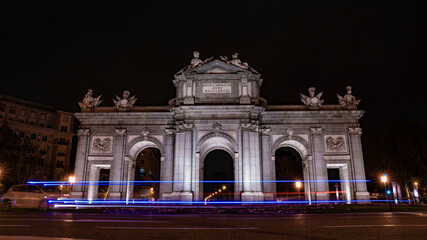 Fototapeta na wymiar Puerta de Alcalá with blue lights of a police car, in the city of madrid during a clear night