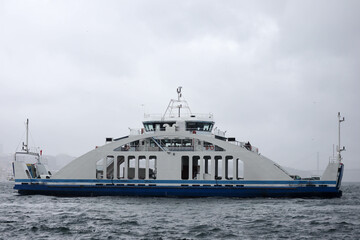 Naklejka premium passenger ferry crosses the Bosporus strait in Istanbul, Turkey in stormy and rainy day