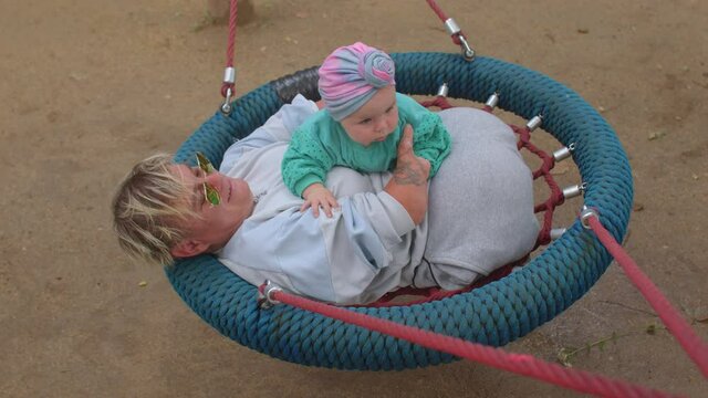 Disabled person with toddler, lifestyle outdoors. Congenital amputations. Amelia is absence of a limb, hemimelia is absence of the forearm or hand. Woman with baby. 