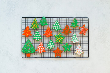 Beautiful holiday cookies in the form of Christmas and New Year trees. Festive cookies on a grid and a light background. Top view, background.