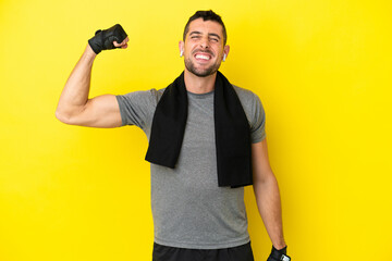 Young sport caucasian man isolated on yellow background doing strong gesture