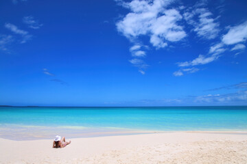 Woman relaxing on Fayaoue beach on the coast of Ouvea lagoon, Mouli and Ouvea Islands, New Caledonia - obrazy, fototapety, plakaty