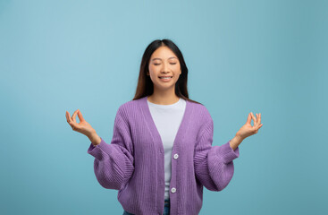 Zen. Peaceful asian lady meditating with closed eyes, practicing yoga and keeping hands in mudra...