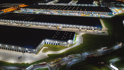 Night aerial view of the warehouse of goods. Logistic center in the industrial area of the city...