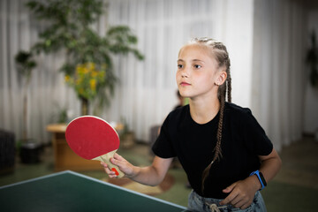 Cute girl playing ping-pong indoors