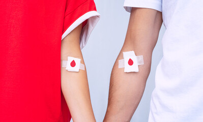 Giving blood saves lives. Blood donation. Man and woman blood donors with bandage