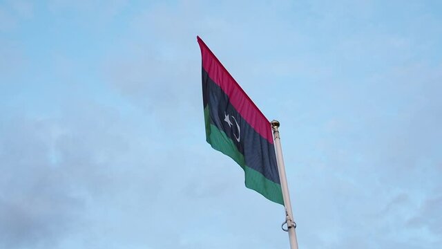 The national flag of Libya flutters in the wind.