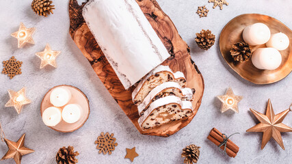 Christmas Stollen background with golden decor and candles, top view