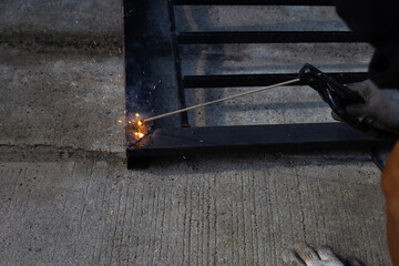 Iron gate repair, Worker hand welding steel