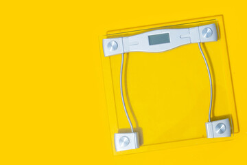 Digital weight scale on yellow background.