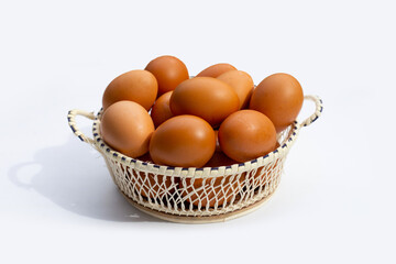 Chicken eggs in bamboo basket on white.