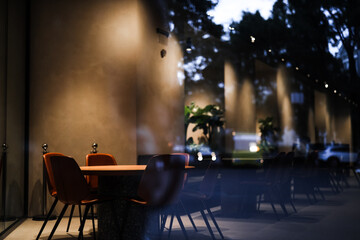 empty restaurant through glass. a round table and soft armchairs around it in an empty restaurant hall. conference hall