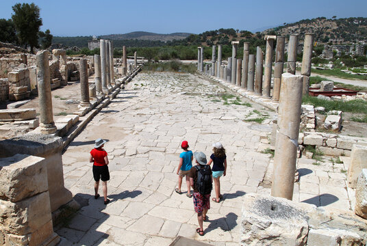 Tourists at colonnade street and ruins in Patara, Antalya, Turkey. Patara was a flourishing maritime and commercial city.