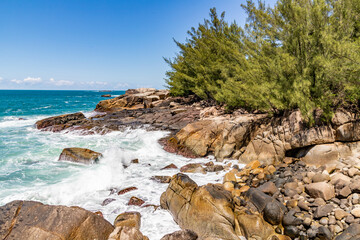 Fototapeta na wymiar Cliff rocks with vegetation and waves