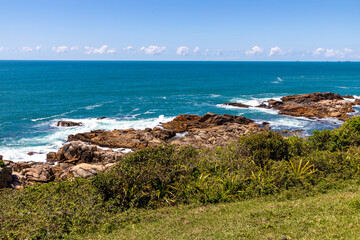 Fototapeta na wymiar Beach view with rocks, waves and vegetation
