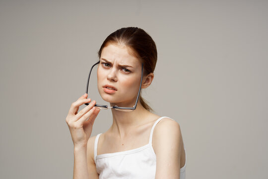 Woman In White T-shirt Glasses In The Hands Of Astigmatism Light Background