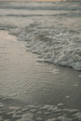 stormy sea wave washes the sandy beach, closeup foamy sea wave, abstract wave background on the baltic sea coast
