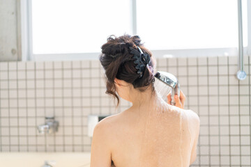 お風呂でシャワーを浴びる若い女性