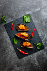 Steamed mussels in shells served with spicy chilly pepper and fresh parsley leaves