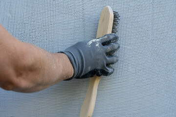 A man making styrofoam surfice rough and structured.