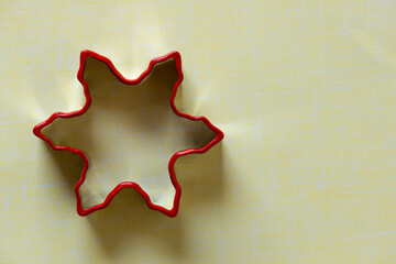 isolated snowflake or star shaped christmas cookie cutter on yellow paper with space