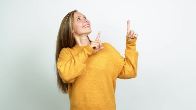 Young blonde girl pointing a great idea and looking up over isolated background