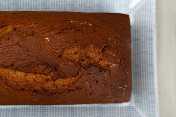 Close up top down view of home baked banana bread loaf on a blue and white rectangle plate. Food baking photo with copy space available