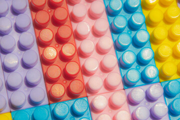 children's play background: the plane of plastic multi-colored bricks, blur, selective focus