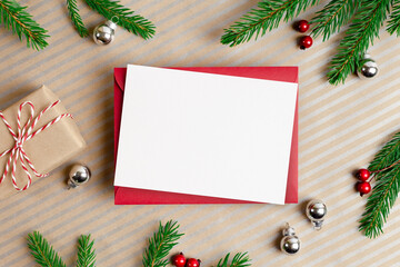 Christmas greeting card mockup with envelope, gift box and festive decorations with fir tree branches