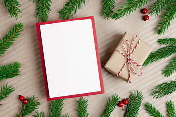 Fototapeta premium Christmas or New Year greeting card mockup with gift box and fir tree branches