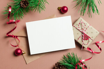 Fototapeta na wymiar Christmas or New Year greeting card mockup with gift box, envelope and festive decorations