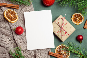 Christmas or New Year greeting card mockup with gift box and festive decorations with fir tree branches