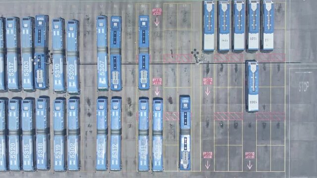Aerial drone view of bus depot, blue city buses top-down view. Public transportation bus hub in Los Angeles. Transfer station, commuter life in American city. 