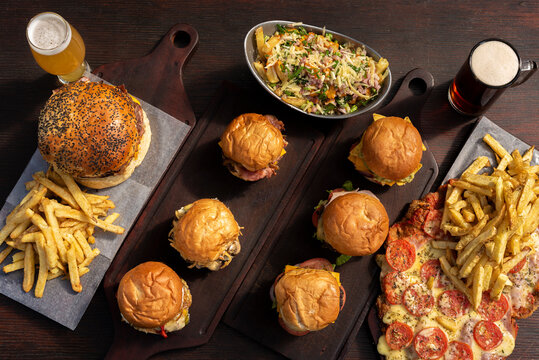 hamburgers with french fries and Milanese a la Neapolitan with beer on wooden board