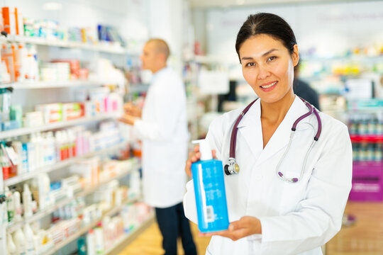 Female pharmacist offers medicine while standing in the trading floor of a pharmacy