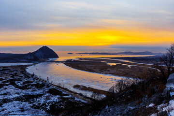Obraz premium Mount Sister in the city of Nakhodka during a bright dawn. Beautiful mountain against the background of the winter sea.