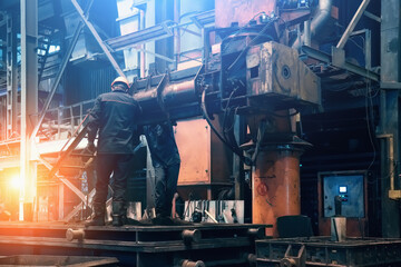 Steel mill interior inside. Workers in workshop of metallurgical plant. Foundry and heavy industry...