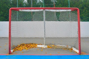 Abandoned hockey goal in fall. Concept of finished field hockey season