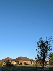 Fototapeta na wymiar Hot air balloon flying over a community