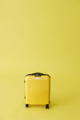 Yellow travel suitcase or trolley luggage bag in studio