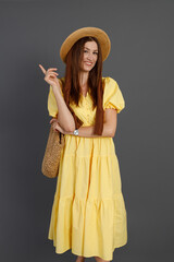 Joyful woman in yellow dress standing in studio