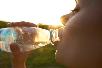 pretty woman drinking water from a bottle face close up