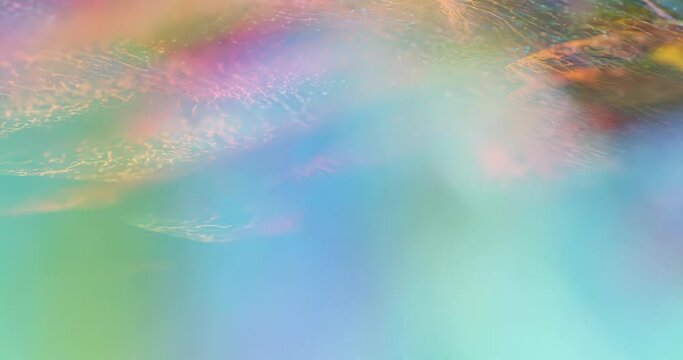 Spectrum of colors, smooth motion with vibrant glittering effect, glowing bokeh. Rainbow aurora abstract background with copy space. liquid flow texture pedal, butterfly wings. 60fps 4K seamless loop