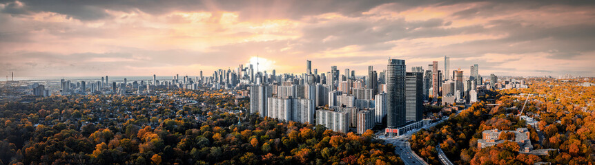 Drone Panorama of Toronto skyline  sunset around fall treetops in the fall 