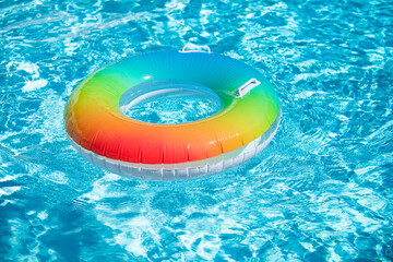 Inflatable rubber ring floating in a blue pool.