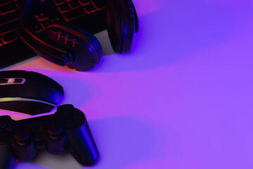 Accessory gaming keyboard joystick mouse headphone with blank space. Gadget for gamer playing video game online in the neon light darkroom. © Chanakon