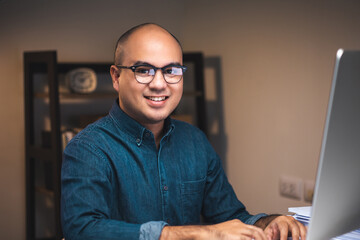 Young asian businessman working with computer in the dark office at night. Attractive handsome...