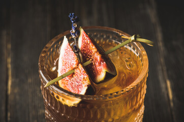 Autumn styled old fashioned cocktail with figs, honey and lavender. Selective focus. Shallow depth of field.