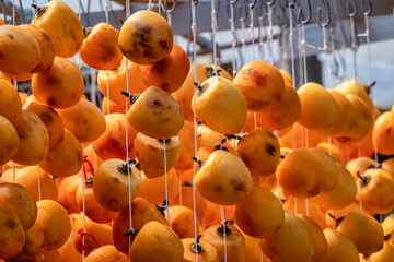 Obraz premium Diospyros kaki fruit or Persimmons are exposed to the sun and natural wind like the Japanese and Korean Hoshigaki method, Da Lat, Vietnam