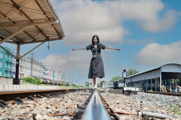 Traveler women walking alone Carrying luggage and waits train on railway station